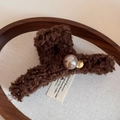 Dettaglio molletta per capelli in peluche marrone con perla champagne e tag d'oro - Marrone Scuro