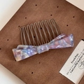 Detail of handmade acetate bow hair comb with purple marble pattern and metal teeth - Purple