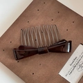 Detail view of a vintage tortoise shell acetate bow hair comb with handmade gold lettering - Dark Brown