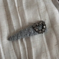 Detail of grey knitted hair clip with heart shaped rhinestones on white fabric - Light Grey Heart