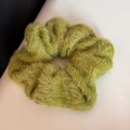 Detailed macro view of an olive green fuzzy knit scrunchie showing soft velvet texture - Green