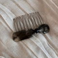Détail d'un peigne à cheveux nœud en acétate gris avec texture marbrée et dents - Peigne nœud étiquette dorée écaille - Gris