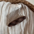 Detailed view of oval brown wool felt hair comb with silver metal teeth on linen - Khaki Plaid Oval Comb