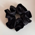 Détail d'un chouchou en velours et satin noir avec volants et texture douce - Noir