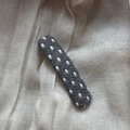 Close-up of dark grey polka dot fabric hair clip with white stitching on linen texture - Polka Dot Rectangle Clip / Gray