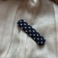 Detail of a black fabric rectangular hair clip with white polka dots on linen texture - Polka Dot Rectangle Clip / Blue