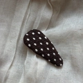 Close-up of handmade brown knitted triangle hair clip with white polka dot pattern detail - Polka Dot Water Drop Clip / Brown