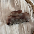 Detail of amber marble acetate hair claw clip with golden lettering on fabric - Light Tortoiseshell
