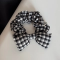 Close-up of black and white gingham bow scrunchie with detailed fabric texture - Black