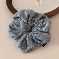 Gros plan détaillé du chouchou en maille bleu et blanc avec étiquette de mode - Chouchou Tricot Flocon Bleu / Bleu