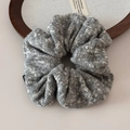 Détail macro du chouchou en tricot gris et blanc montrant la texture fine et l'étiquette - Chouchou Tricot Flocon Gris / Gris