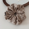 Gros plan d'un chouchou en tricot marron et blanc avec texture tissée et étiquette noire - Chouchou Tricot Flocon Café / Marron