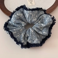 Close-up of blue and white knitted oversized scrunchie with fringe texture details - Fuzzy Edge Snowflake Knit Blue Scrunchie