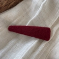 Close-up of a burgundy felt hair clip with soft wool texture on rustic linen fabric - Triangle Solid Color Woolen - Red