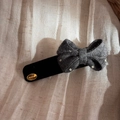 Nahaufnahme einer dunkelgrauen gepunkteten Strick-Haarklammer mit goldenem Siegel - Knit Bow Rectangular BB Clip / Grau