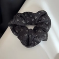 Close-up of dark grey floral scrunchie with white leaf patterns and plush texture - Scrunchie / Black Style