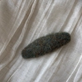 Detailed close-up of dark green felt fabric hair clip texture on white linen background - Oval / Green