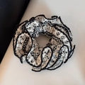 Detailansicht der doppellagigen Webstruktur und Spitzeneinfassung des schwarz-weißen Scrunchies - Weiß