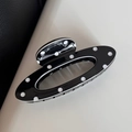Close-up of black and white polka dot hair claw clip with glossy finish and oval hollow design - Black Polka Dot Oval Style