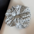 Detailaufnahme von weißem Scrunchie mit zartem schwarzen Blumen- und Paisley-Muster - Weiß
