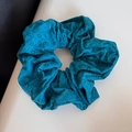 Detailansicht der Textur des blauen Blumen-Haargummis mit elastischem Design - Blau