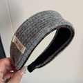 Detailansicht graues Strick-Haargummi mit Leopardenmuster-Futter und Logo-Aufnäher - Graues Stirnband