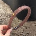 Détail d'un serre-tête marron en laine fait main avec étiquette Love dorée et douce - Marron