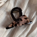 Detail view of handmade triangle hair claw clip with pink tortoise shell pattern and logo - Triangle Acetate Patch (Light Tortoiseshell) / Light Tortoiseshell
