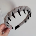 Detail view of the long anti-slip teeth and grey knitted wool texture on the headband - Gray