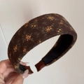 Dettaglio ravvicinato di cerchietto in tessuto marrone scuro con motivi floreali vintage - Cerchietto Largo Floreale Marrone