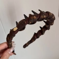 Dettaglio del cerchietto floreale con denti antiscivolo e targhetta in metallo dorato - Cerchietto con Denti Floreale Marrone