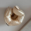 Detailed close-up of champagne satin scrunchie with soft padding and brand logo tag - Off White