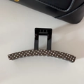 Close-up detail of a French style brown polka dot hair claw clip with sturdy inner teeth - Coffee (Large Claw)