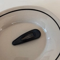 Gros plan sur la barrette en cuir noir en forme de goutte avec coutures et texture fines - goutte / Noir