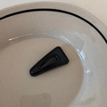 Détail d'une pince à cheveux triangulaire en similicuir noir avec couture sur assiette - Petit Triangle / Noir