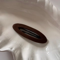 Gros plan d'une barrette en velours marron sur un plateau en céramique blanc - Ovale Café Foncé