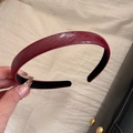 Détail d'un serre-tête en similicuir rouge foncé avec texture serpent et doublure douce - Rouge