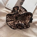 Detail of oversized leopard print hair scrunchie with black ruffled edges on linen fabric - Black Trim Leopard Scrunchie