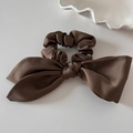 Detail of elegant dark brown satin bow hair tie with premium silky texture and gloss - Coffee