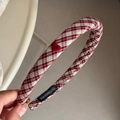 Detail eines roten karierten Stirnbands mit Herzakzent und einem handgemachten Etikett innen - Rot