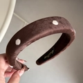 Detailed view of brown velvet headband with white polka dots and embroidered brand label - Velvet Polka Dot Headband - Coffee