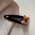 Dettaglio del fermaglio per capelli a forma di orso in velluto con placca in metallo Love - caffè