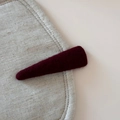 Close-up of a burgundy wool felt triangular hair clip on a textured beige fabric base - Solid Color Woolen Triangle BB Clip / Red