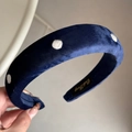 Detail of navy blue velvet headband with white polka dots and internal gold brand logo - Velvet Polka Dot Headband - Navy