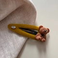 Dettaglio macro di orsetto floccato su fermaglio per capelli in velluto giallo senape - Giallo