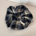 Detail of blue and grey plaid fabric scrunchie featuring a white hand made woven label - Plaid Scrunchie - Black