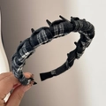 Close-up of black and white plaid fabric headband with plastic teeth for secure grip - Toothed Plaid Headband - Black