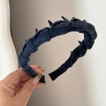 Detail of dark blue denim headband with black punk spikes held against grey background - Toothed Plaid Headband - Navy