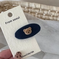 Close-up of cute brown flocked bear head on a velvet oval hair clip over white display card - Blue