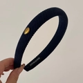 Detailed macro view of navy blue ribbed fabric headband with oval gold Korea metal tag - Navy Blue